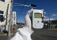 Greenpeace team member holding Geiger Counter